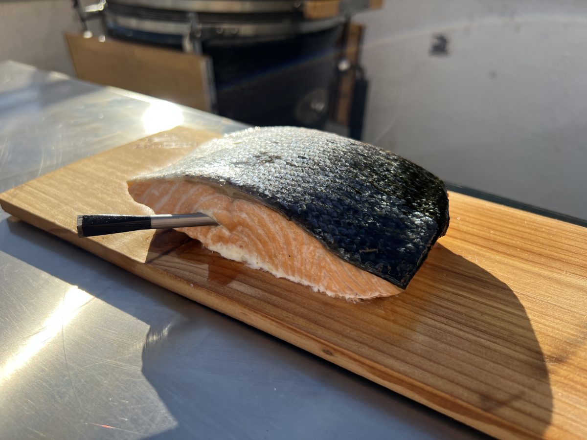 Salmón ahumado a la parrilla sobre tabla de cedro en Kamado fácil